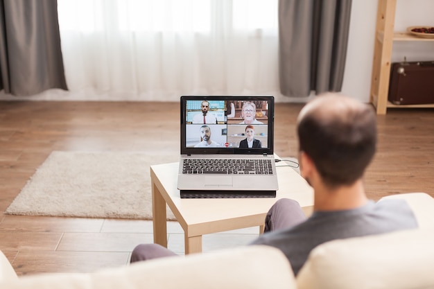 Man working from home in a video call with his team during quarantine.