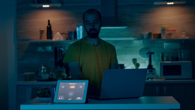 Wi-Fiガジェットで雰囲気を制御するスマートハウスで働く男