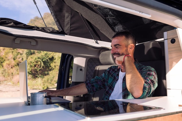 Man working on his laptop from his camper van