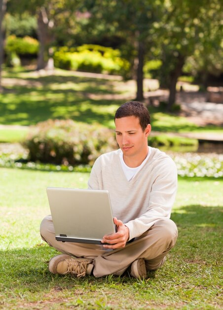 Человек, работающий на своем ноутбуке в парке