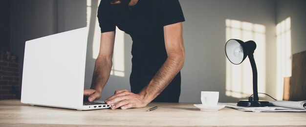 写真 机の上のコンピューターで働く男