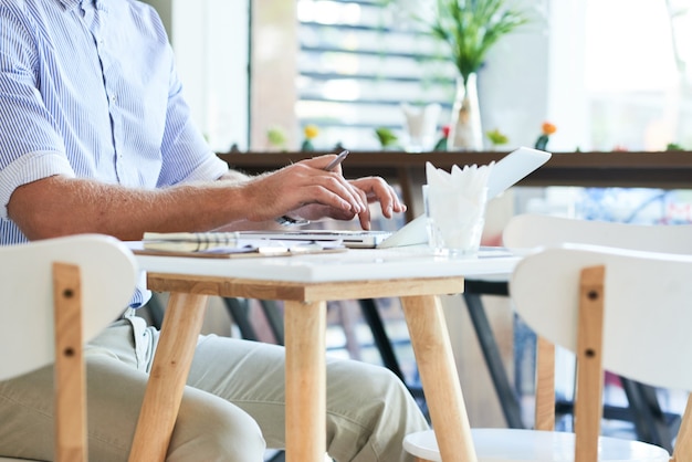 Man Working on Laptop in Cafe