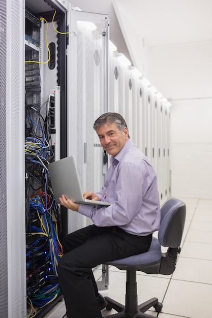 Man working on laptop to check servers