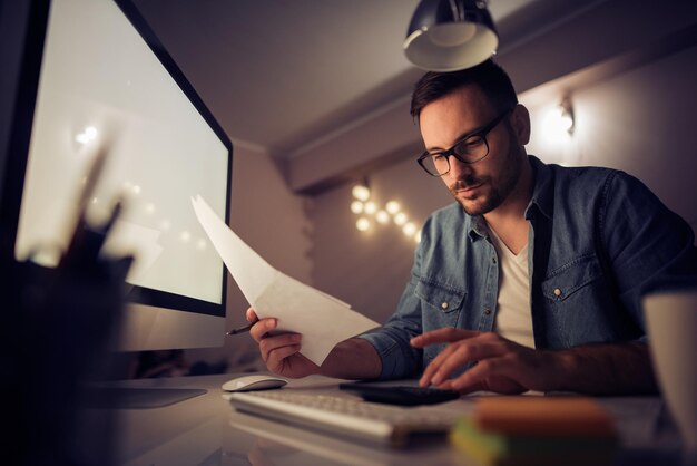 Uomo che lavora al computer portatile a casa