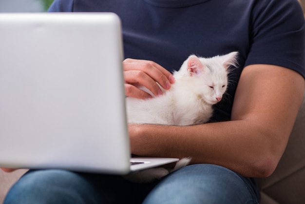 Man working on laptop and playing cat