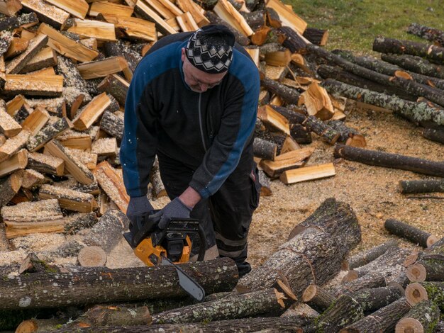 Man working on log logs in forest