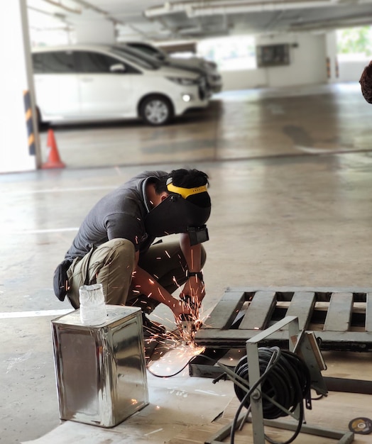 Photo man working over metal on floor