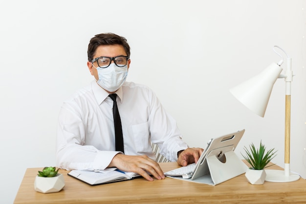 Man working in the office in a medical mask