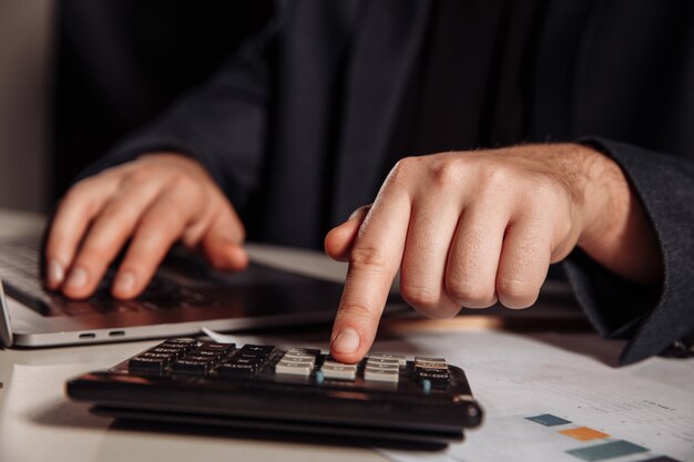 Man working in office using calculator