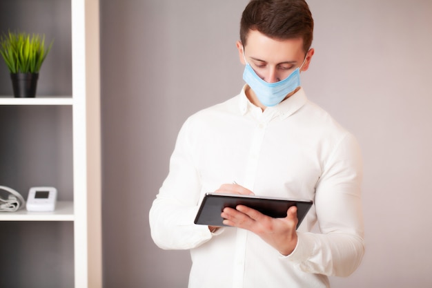 Man working in the office wearing a mask for protection from coronavirus