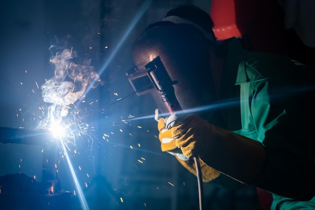 写真 暗で金属を加工する男