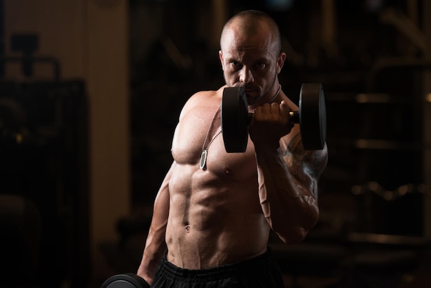 Man Working Out Biceps In A Dark Gym  Dumbbell Concentration Curls