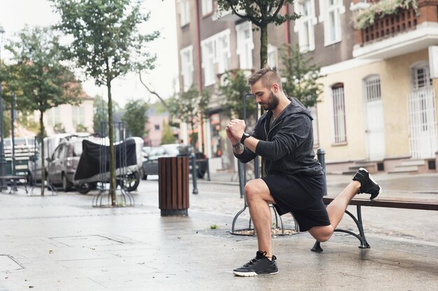 A man working out on the city street on the sidewalk and bench Healthy lifestyle