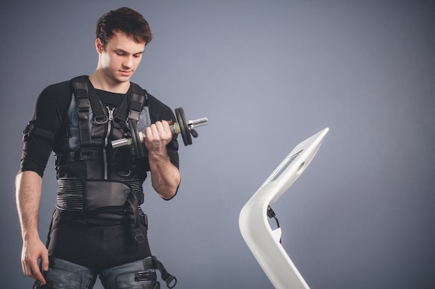 Man working out EMS training with dumbbell