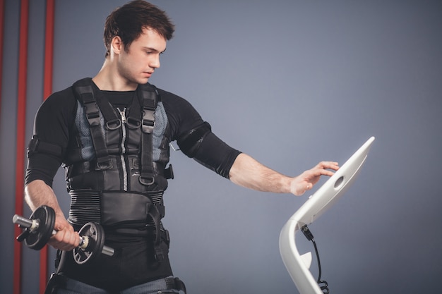 Man working out EMS training with dumbbell