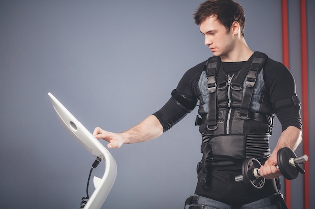 Man working out EMS training with dumbbell