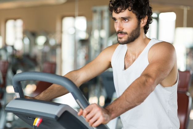 Uomo che lavora su un tapis roulant in palestra