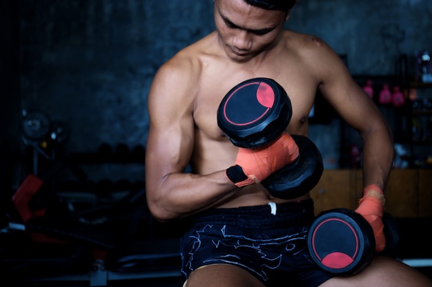 Man working out with dumbbells in gym.