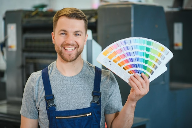 Man working in printing house with paper and paints