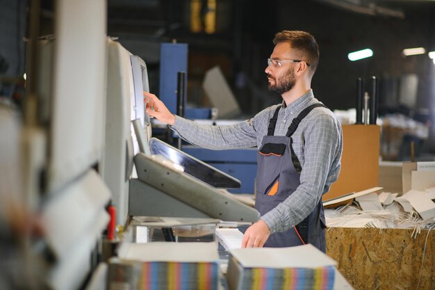 Man working in printing house with paper and paints