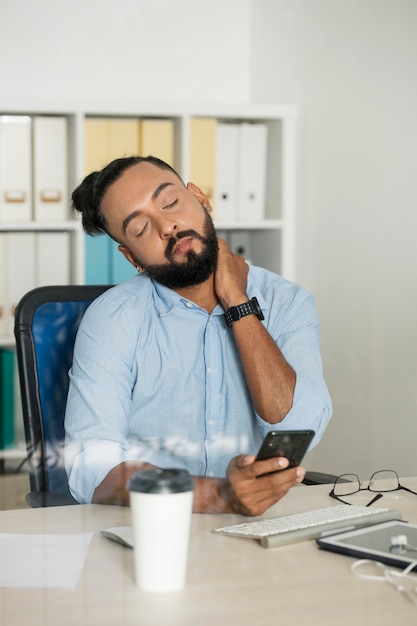 写真 彼の電話をチェックしながら働いている男