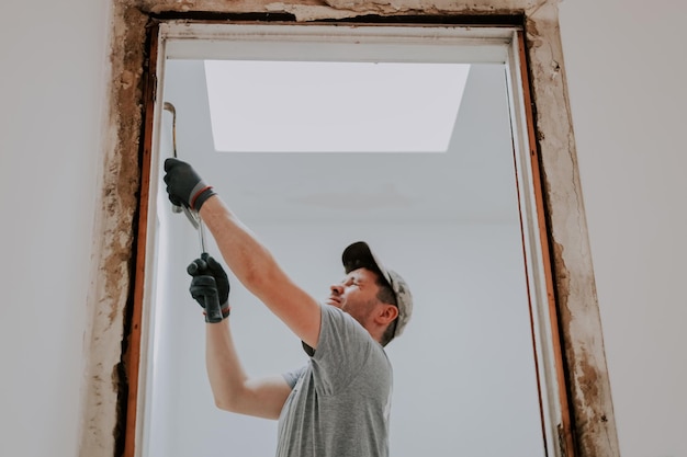 A man working with a crowbar in a doorway