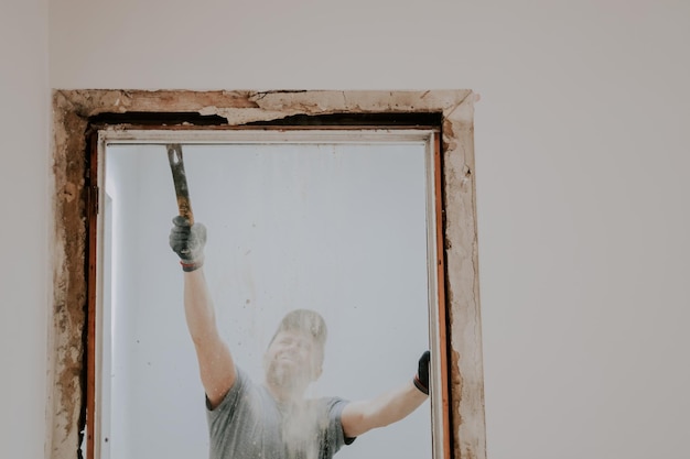 A man working with a crowbar in a doorway