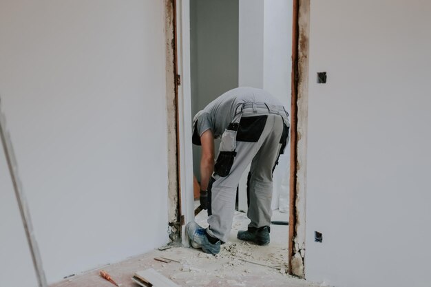 A man working with a crowbar in a doorway