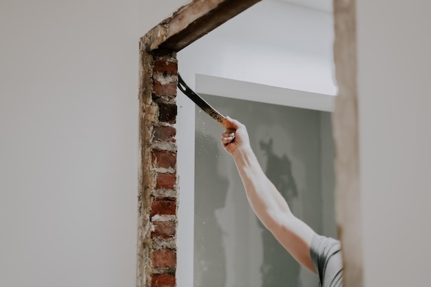 A man working with a crowbar in a doorway