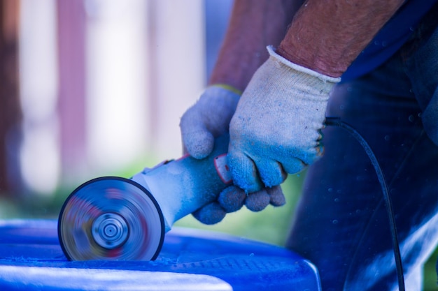 Man working with grinder saw close up view on tool electric saw\
and hands of worker with sparks worker cutting with grinder