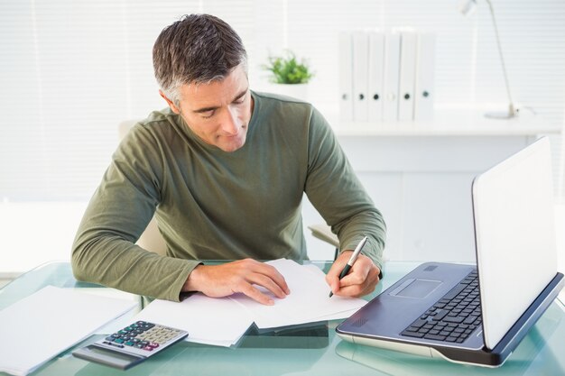 Man working with laptop and writing 