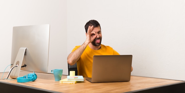 Man working with laptot in a office makes funny and crazy face emotion