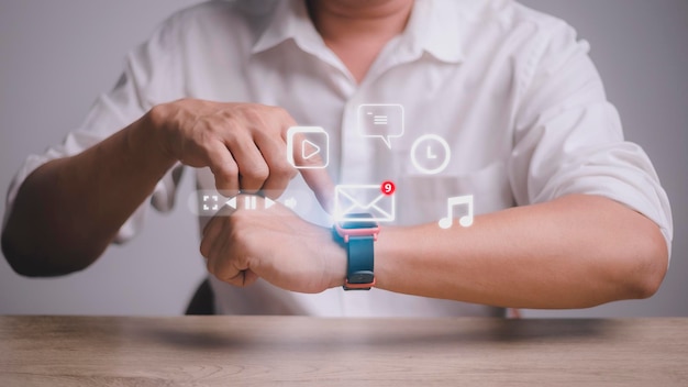 Man working with smart watch in office New message received notification on screen