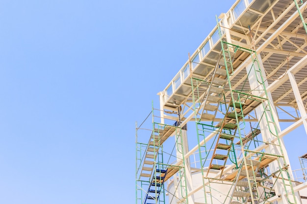 Man Working on the Working at height with blue sky at construction site