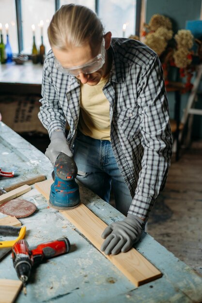 Foto uomo che lavora in un laboratorio di fabbricazione di mobili riutilizza vecchi materiali per creare una consapevolezza del nuovo prodotto