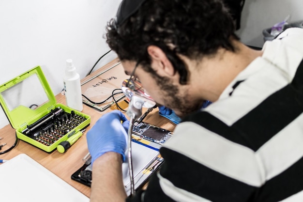 A man works on a cell phone in a lab.