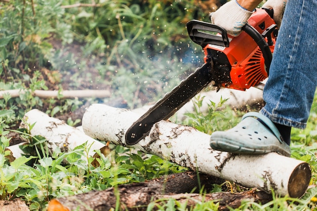 Photo a man works on creating a house, sawing wood, building, saw, power saw, chisel, nails, screws