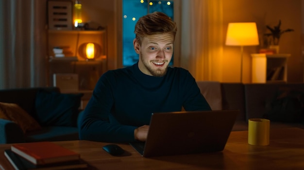 a man works on his laptop at night.
