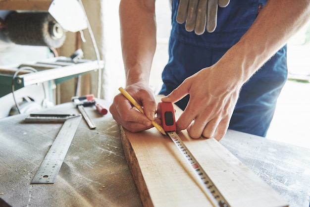 A man works in a joiner's shop, working with a tree.