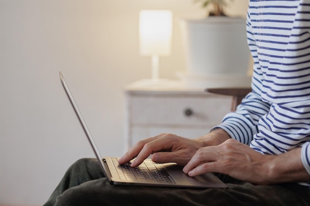Мужчина работает на ноутбуке дома дизайнер-фрилансер или топ-менеджер работает онлайн или смотрит