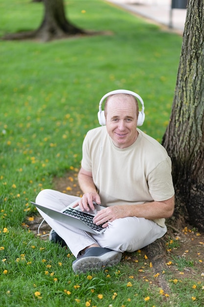 A man works on a laptop in the park