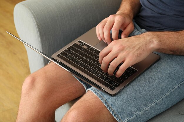 A man works on a laptop on a sofa