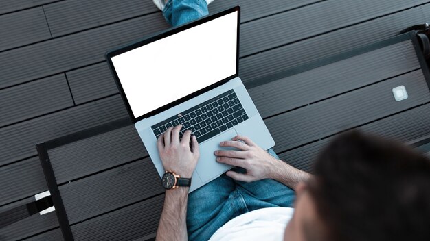 Man works on laptop on the street