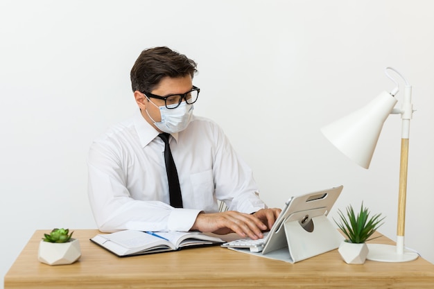 Man works in the office in a medical mask