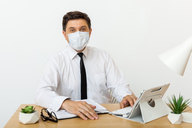 Man works in the office in a medical mask