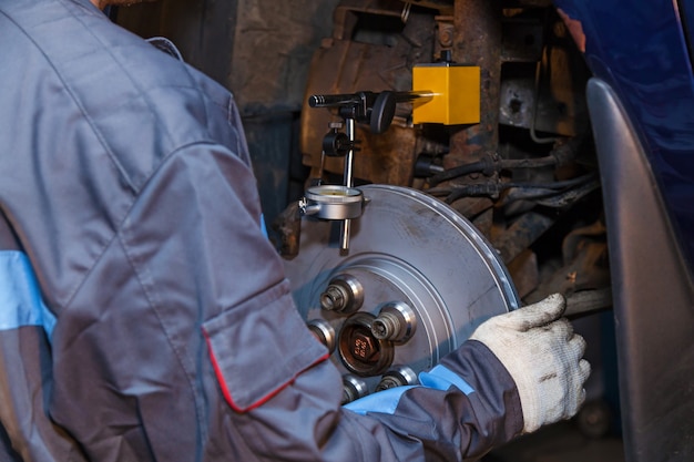 A man works at a service station The mechanic is engaged in repairing the car