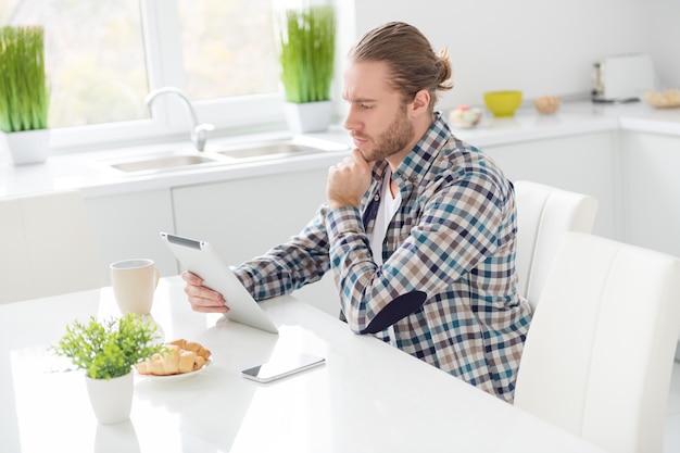 man works on tablet in modern kitchen