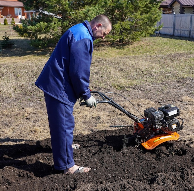 Мужчина работает в овощном саду в начале весны копает землю работает земледельцем