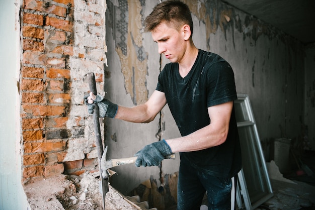 A man works with an ax and a hammer