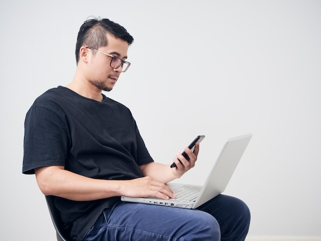 Man works with smartphone and laptop